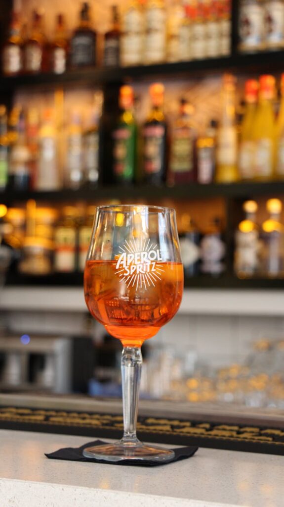 A refreshing Aperol Spritz cocktail in a stylish bar setting, perfect for summer vibes.