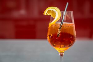Bright Aperol spritz with lemon slice on a glass, perfect for summer refreshment.